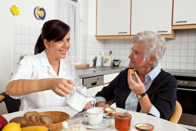 lady assisting elderly with her meals